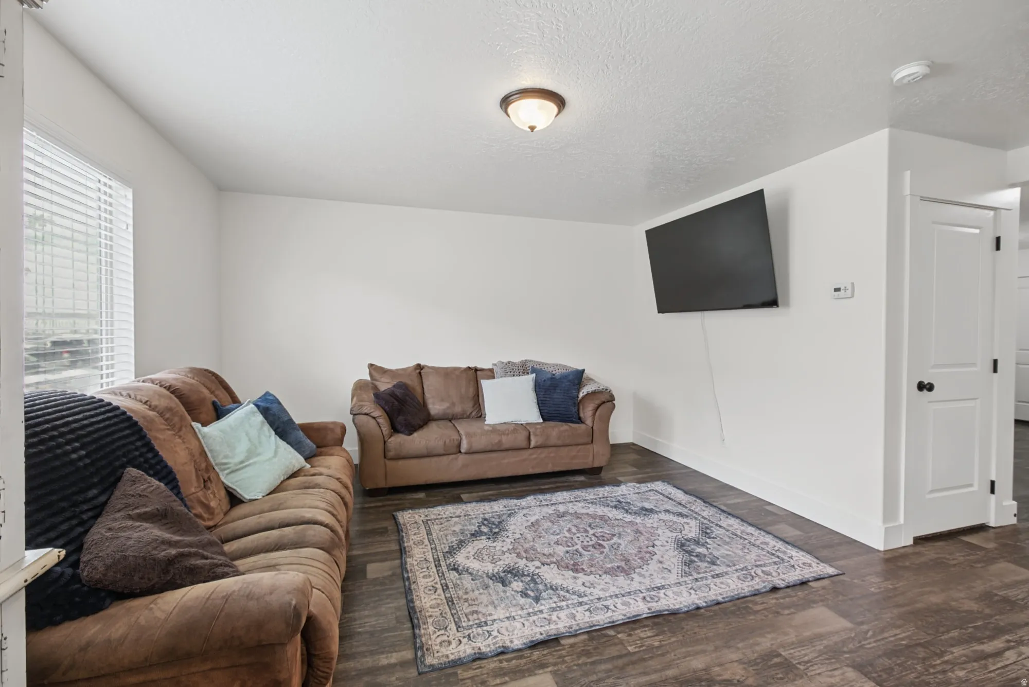 Wood-finish flooring, white walls, white trim, and a ceiling-mounted light fixture