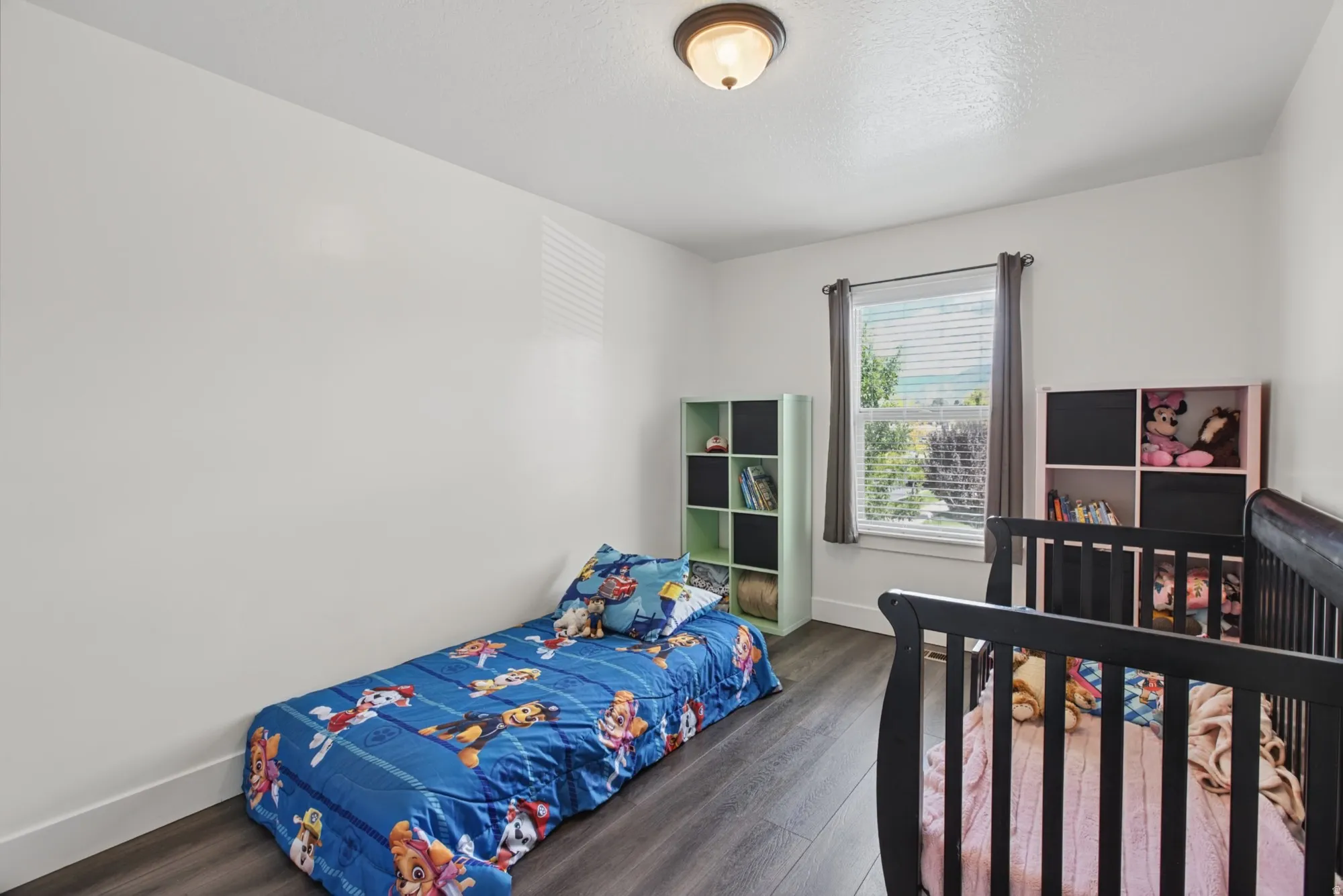 Wood-finish flooring, single window, overhead flush-mount lighting, and white walls