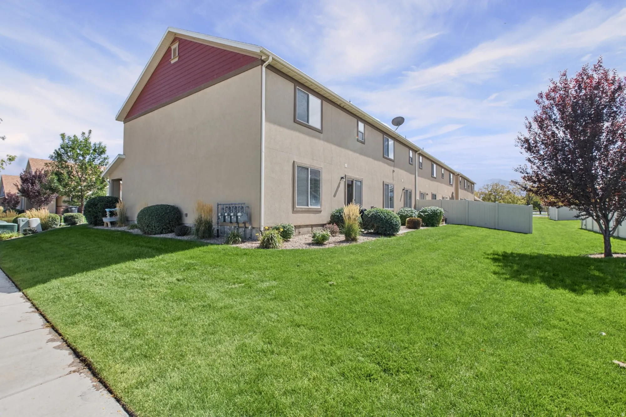Exterior stucco siding with a red gable accent and white trim