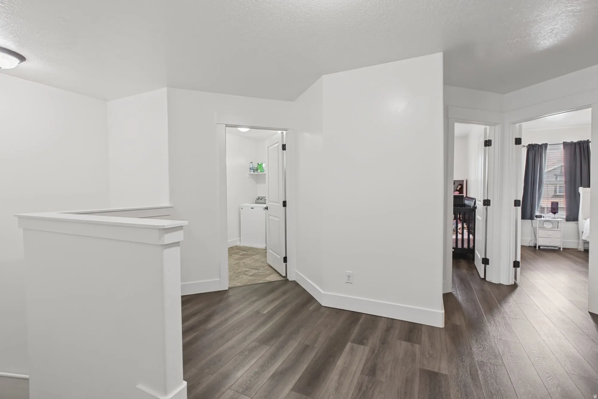 Wood-finish flooring throughout, white baseboards, and bright white walls