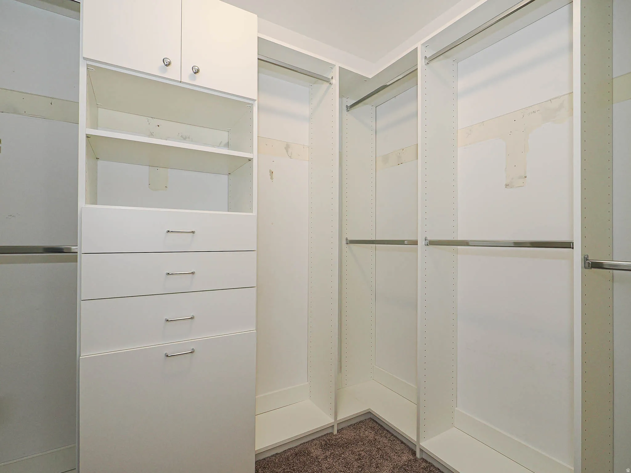 Built-in white cabinetry with chrome hardware, integrated shelving, and multiple hanging rods