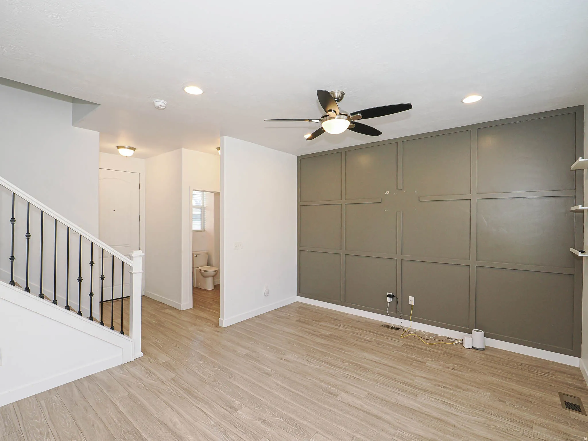 Wood-finish flooring, recessed lighting, and a contemporary ceiling fan