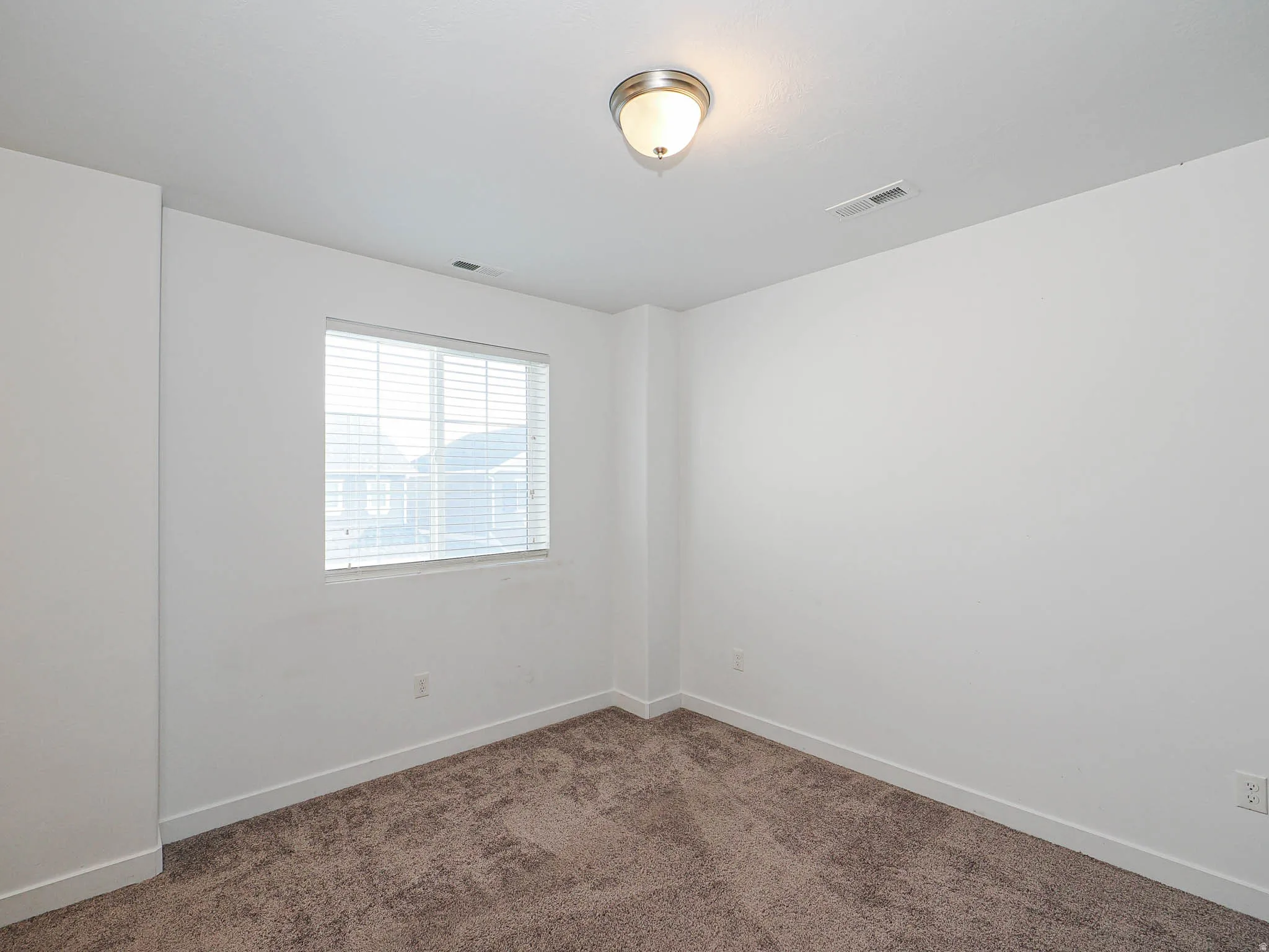 Neutral wall finishes, recessed window with blinds, overhead flush mount lighting, and carpet flooring