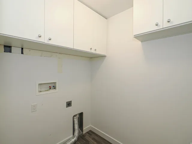 Built-in white cabinetry, wood-finish flooring, and white walls