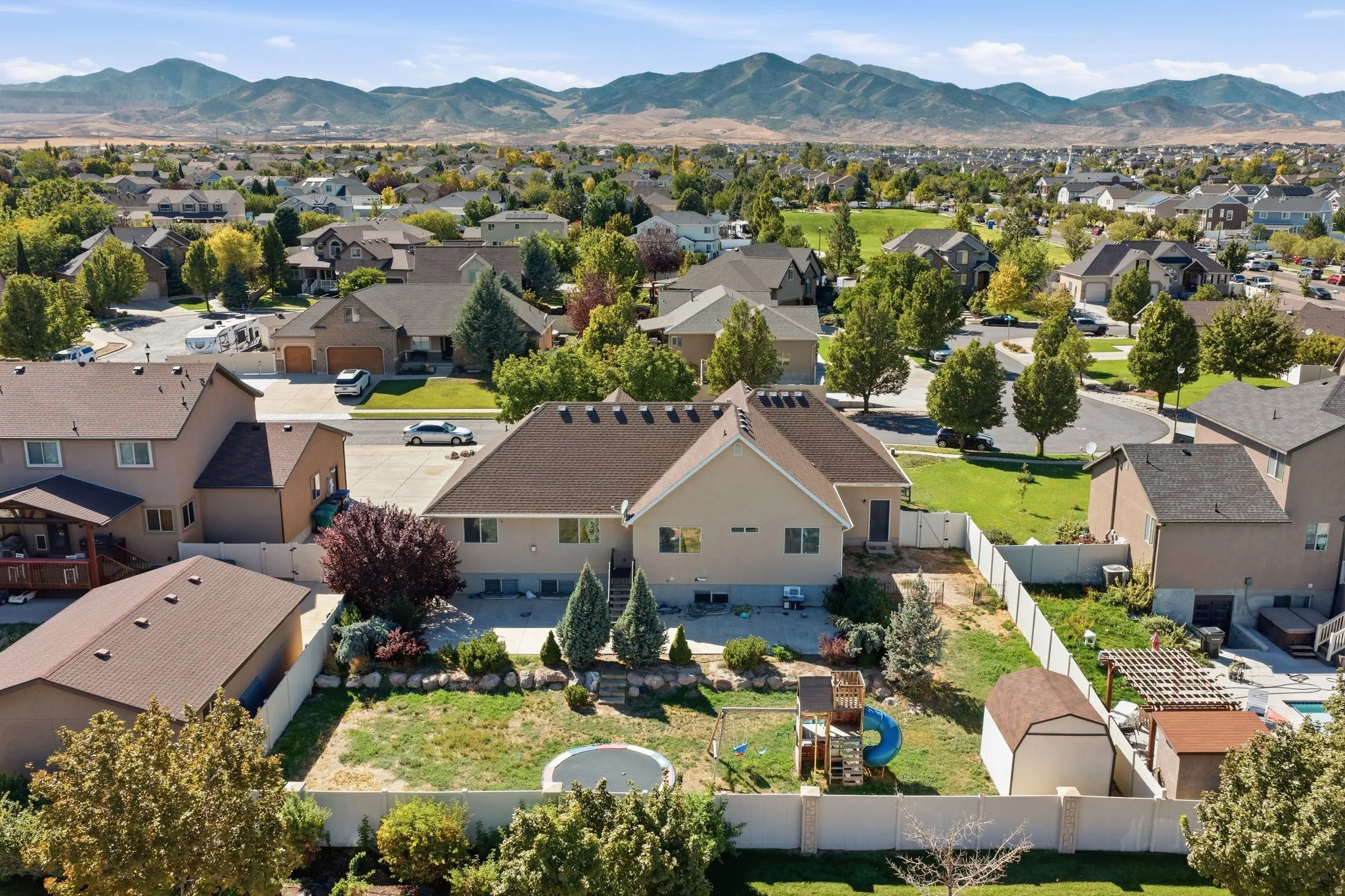 Expansive residential neighborhood with mature trees and mountain scenery