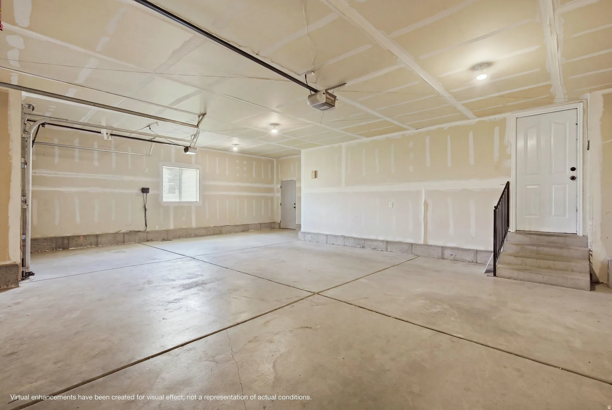 Spacious garage with concrete flooring, multiple recessed light fixtures, a side entry door with stairs, and a window for natural light