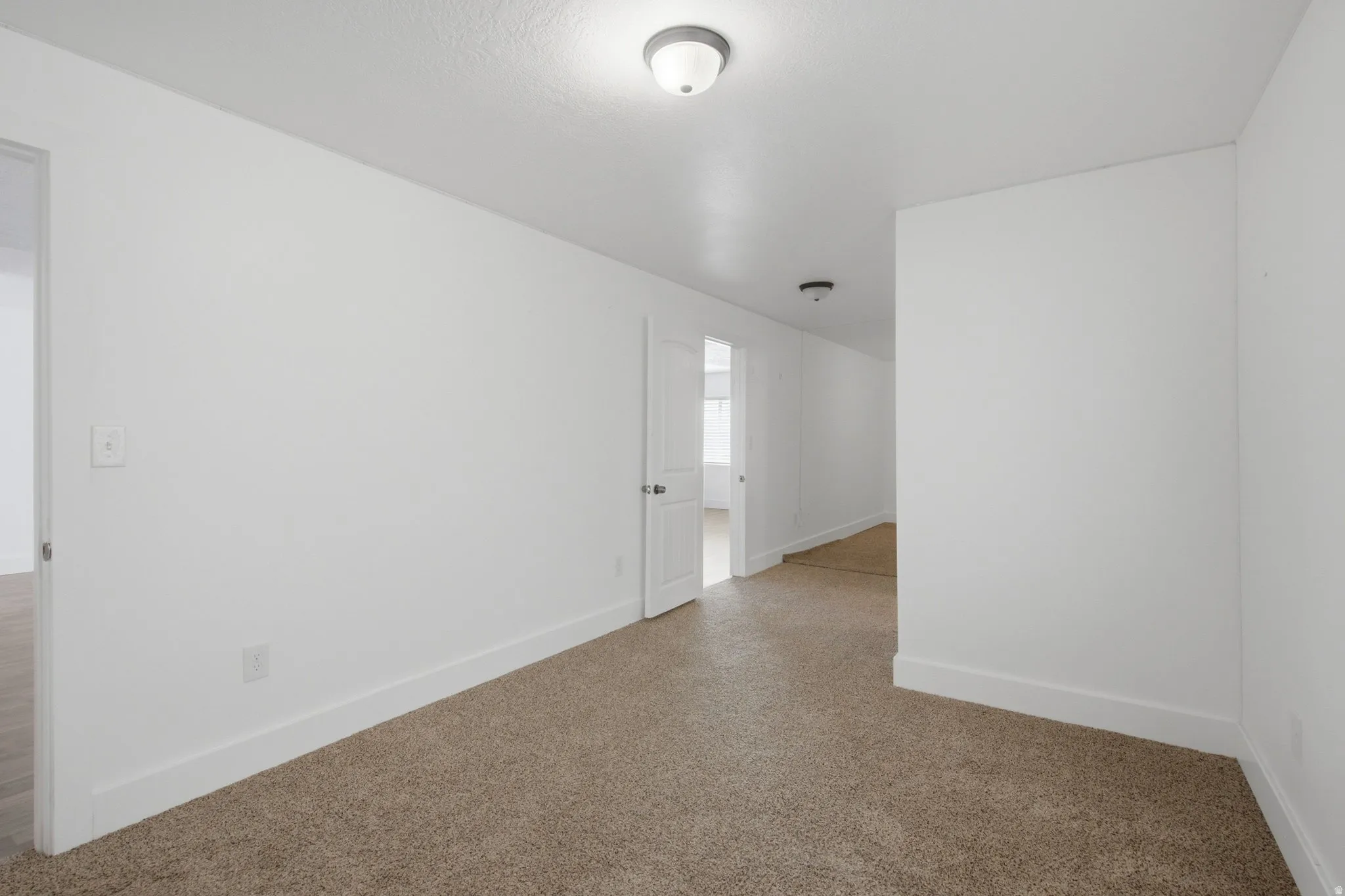 Neutral wall colors, white trim, and recessed lighting create a bright interior