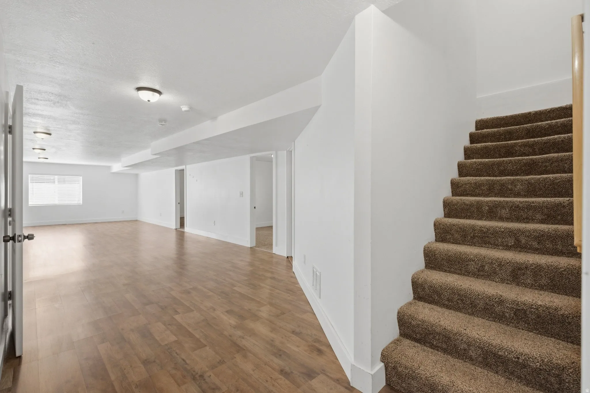 Spacious interior featuring wood-finish flooring, white walls, and recessed lighting