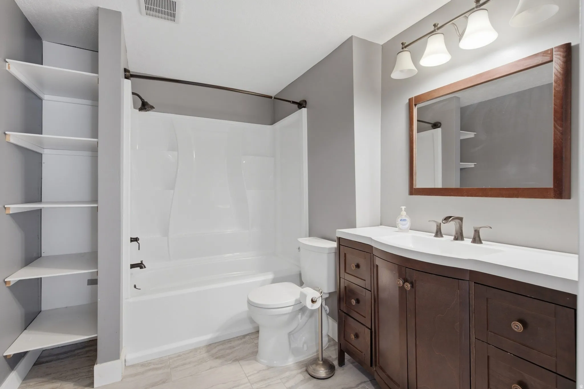White tub and shower combination with dark bronze fixtures