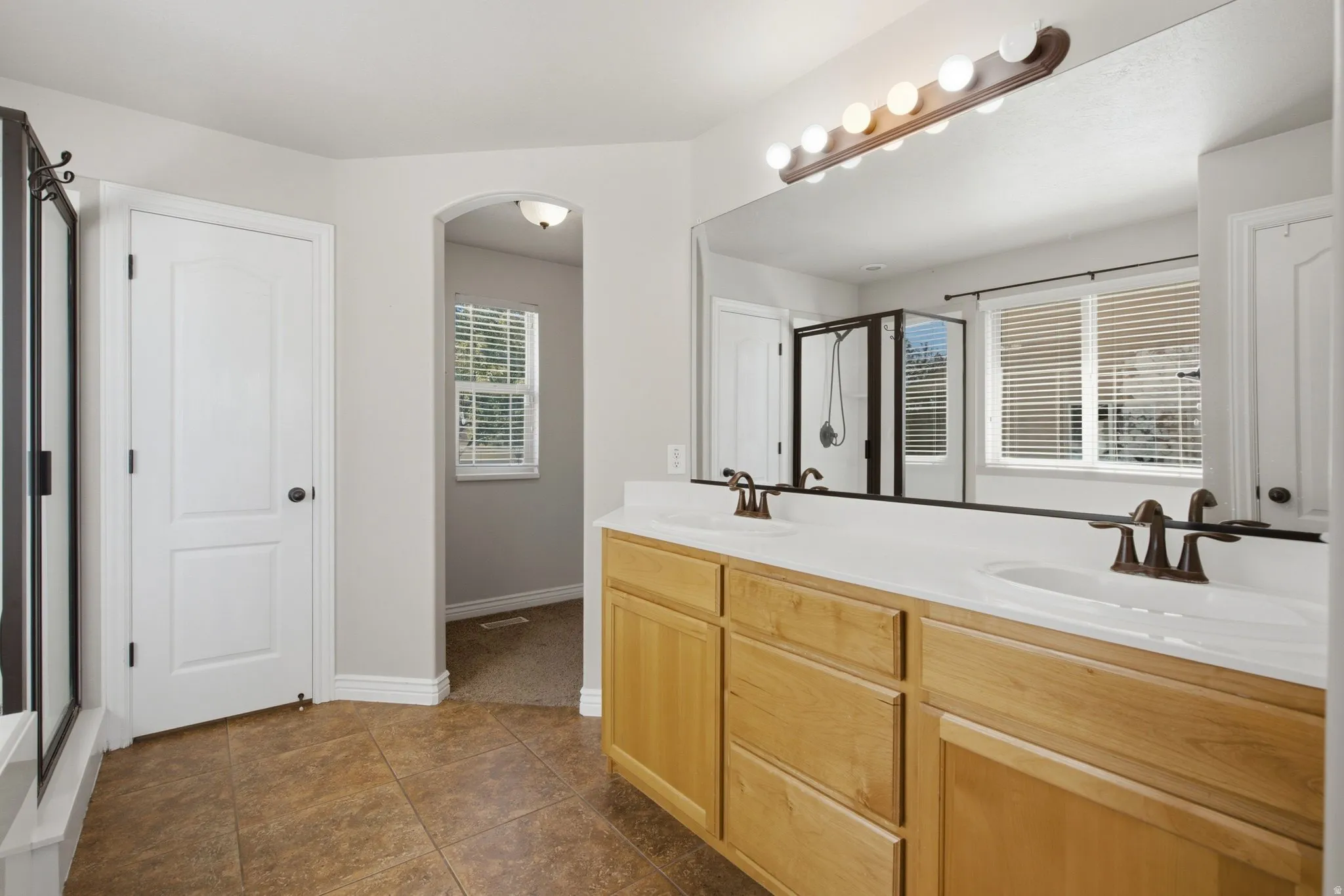 Dual vanity with integrated sinks, wood-finish cabinetry, and a full-width mirror