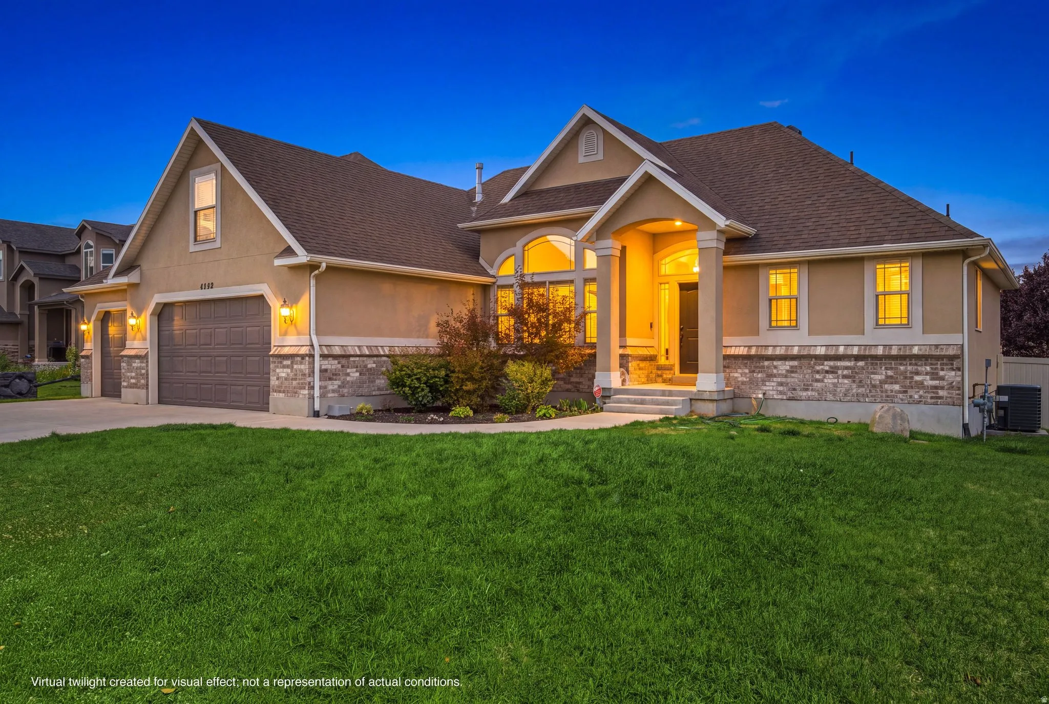 Stucco exterior with stone veneer accents, arched windows, covered entry, and attached two-car garage
