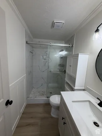 Walk-in shower with clear glass enclosure, white marble-style wall tile, and hex tile flooring