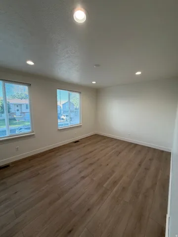 Recessed lighting, wood-finish flooring, and white trim