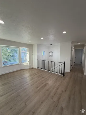 Wood-finish flooring throughout, recessed lighting, and a decorative chandelier