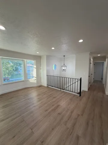 Wood-finish flooring throughout, recessed lighting, and a decorative chandelier