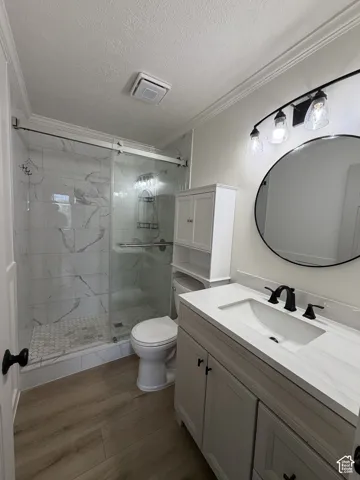 Walk-in shower with sliding glass doors, white tiled walls, and hexagonal floor tile