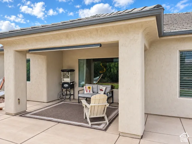 Covered patio with stucco finish, tile roof, and concrete flooring