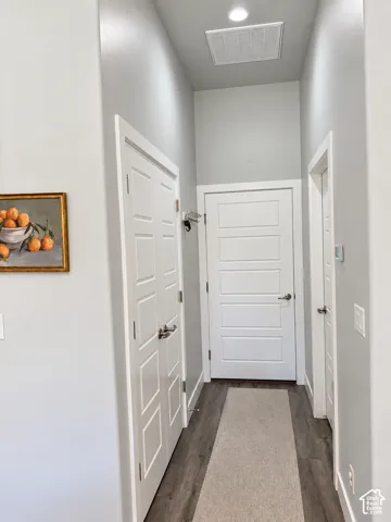 Recessed ceiling lighting, wood-finish flooring, white paneled doors, and light gray wall paint