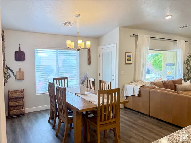 Open-concept living area featuring wood-finish flooring, recessed lighting, and a chandelier light fixture