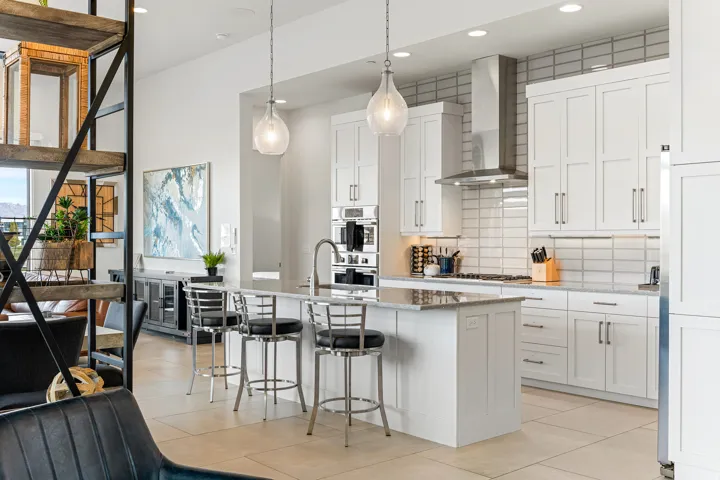 Kitchen featuring white shaker cabinetry, stainless steel appliances, a center island with bar seating, pendant lighting, and a tile backsplash