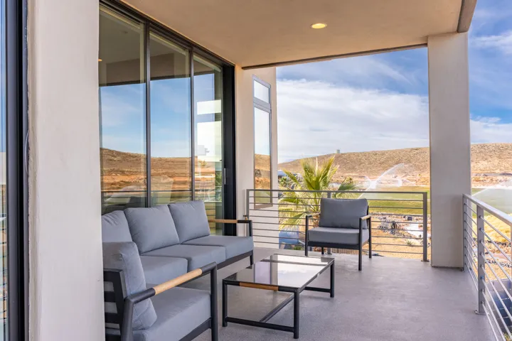 Expansive covered patio featuring a concrete surface, sliding glass doors, and modern cable railings