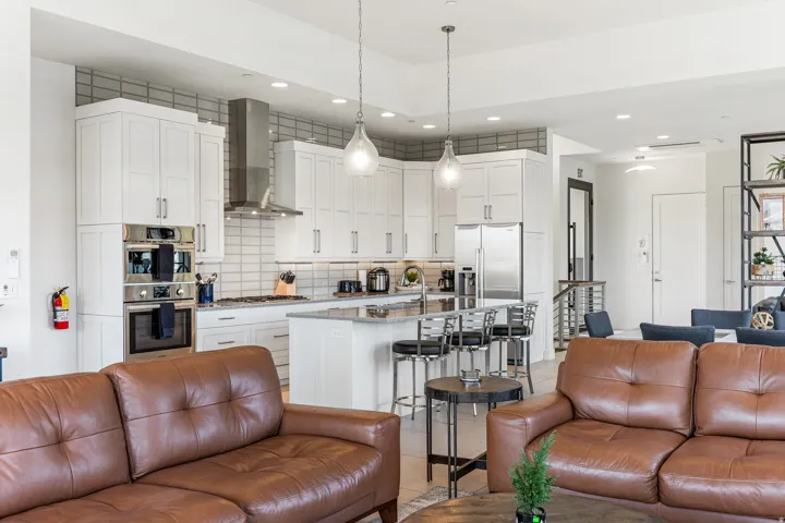 Gourmet kitchen with white shaker cabinetry, stainless steel appliances, and a central island with bar seating