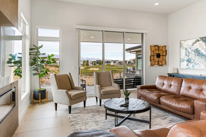 Spacious living area featuring high ceilings, large windows, and sliding glass doors