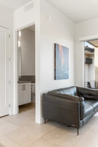 Neutral-toned tile flooring, white walls, and a white interior door