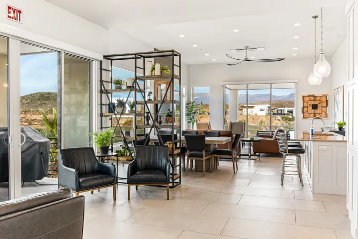 Spacious open-concept interior featuring large format tile flooring, expansive window walls, and recessed lighting
