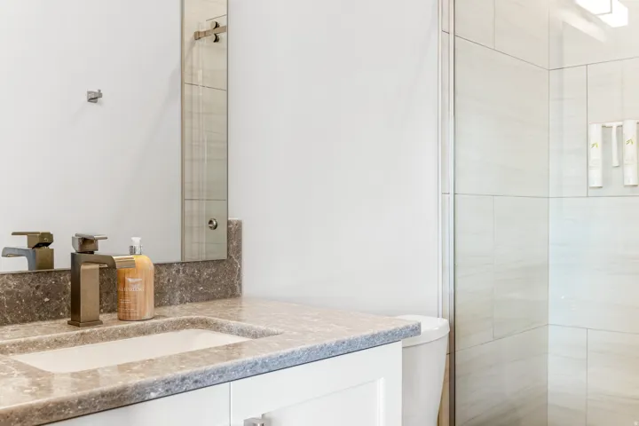 Vanity with an integrated sink, stone countertop, and contemporary bronze faucet
