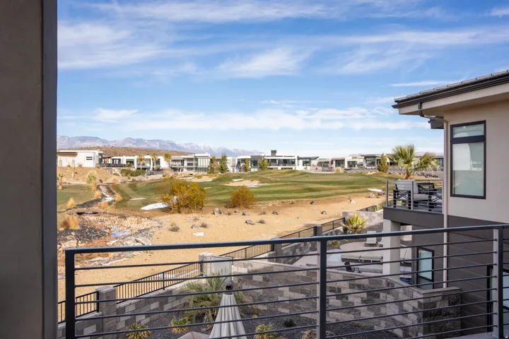 Expansive landscape with a golf course, mountain backdrop, and contemporary residential architecture