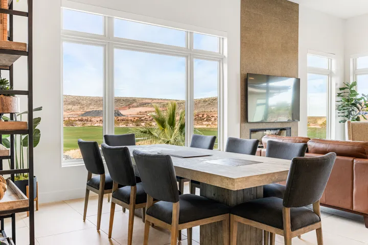 Expansive floor-to-ceiling windows, stone-clad fireplace, and neutral tile flooring