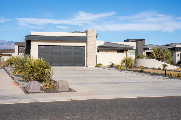 Modern exterior with a flat roofline, stucco facade, and an integrated garage featuring a paneled door