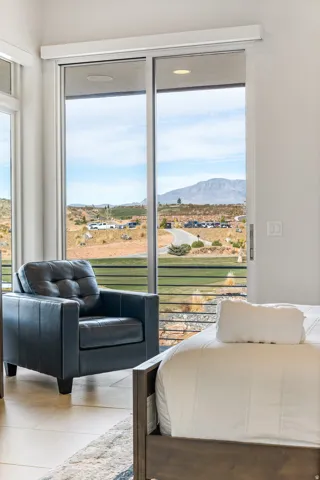 Sliding glass door leading to exterior, recessed ceiling lighting, light-toned tile flooring