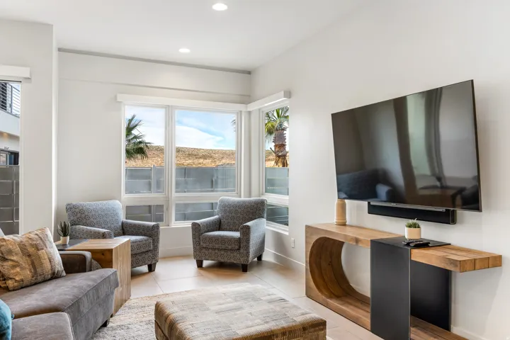 Recessed lighting, large windows, tile flooring, and a wall-mounted entertainment console