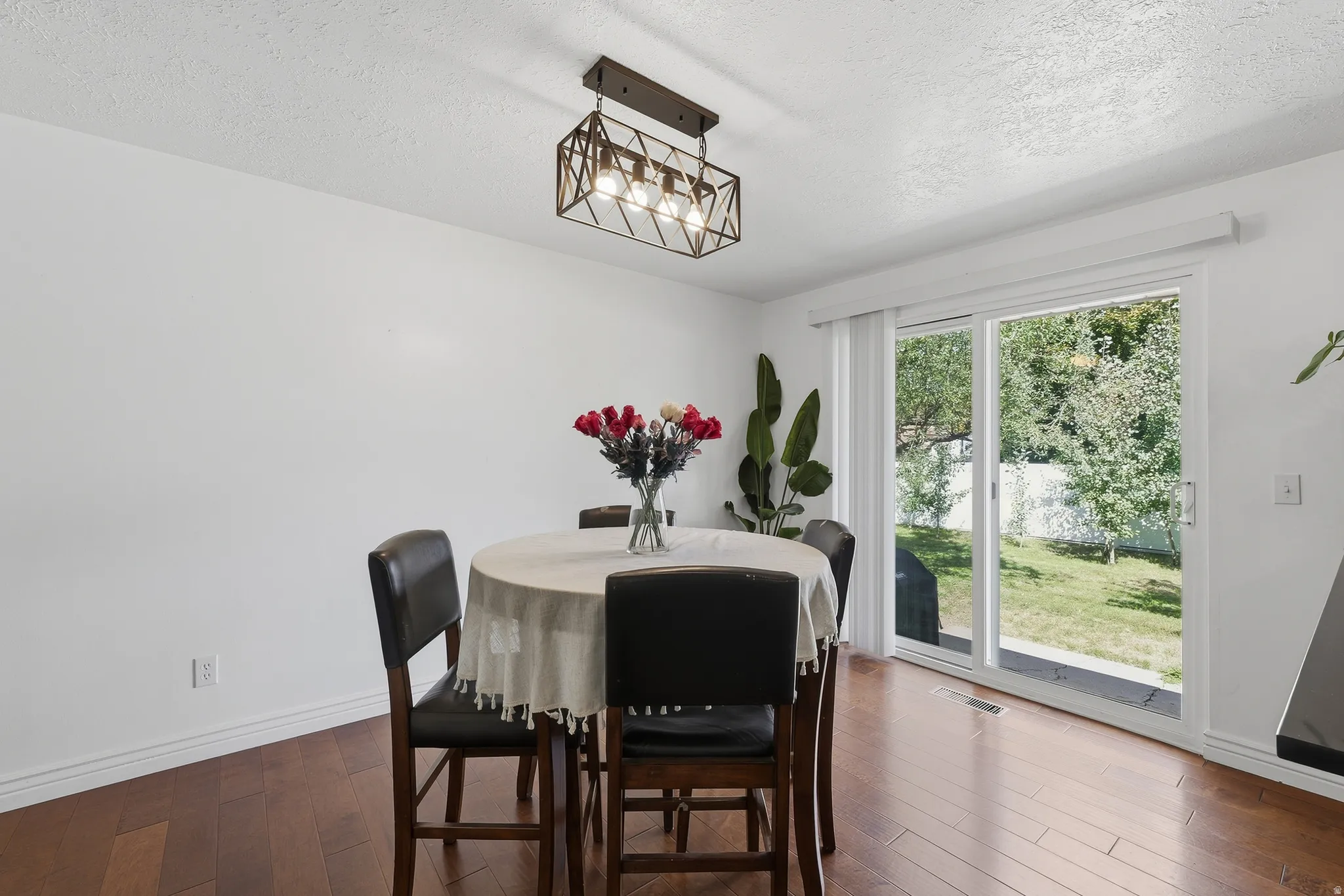 Wood-finish flooring, white walls, and a contemporary ceiling fixture