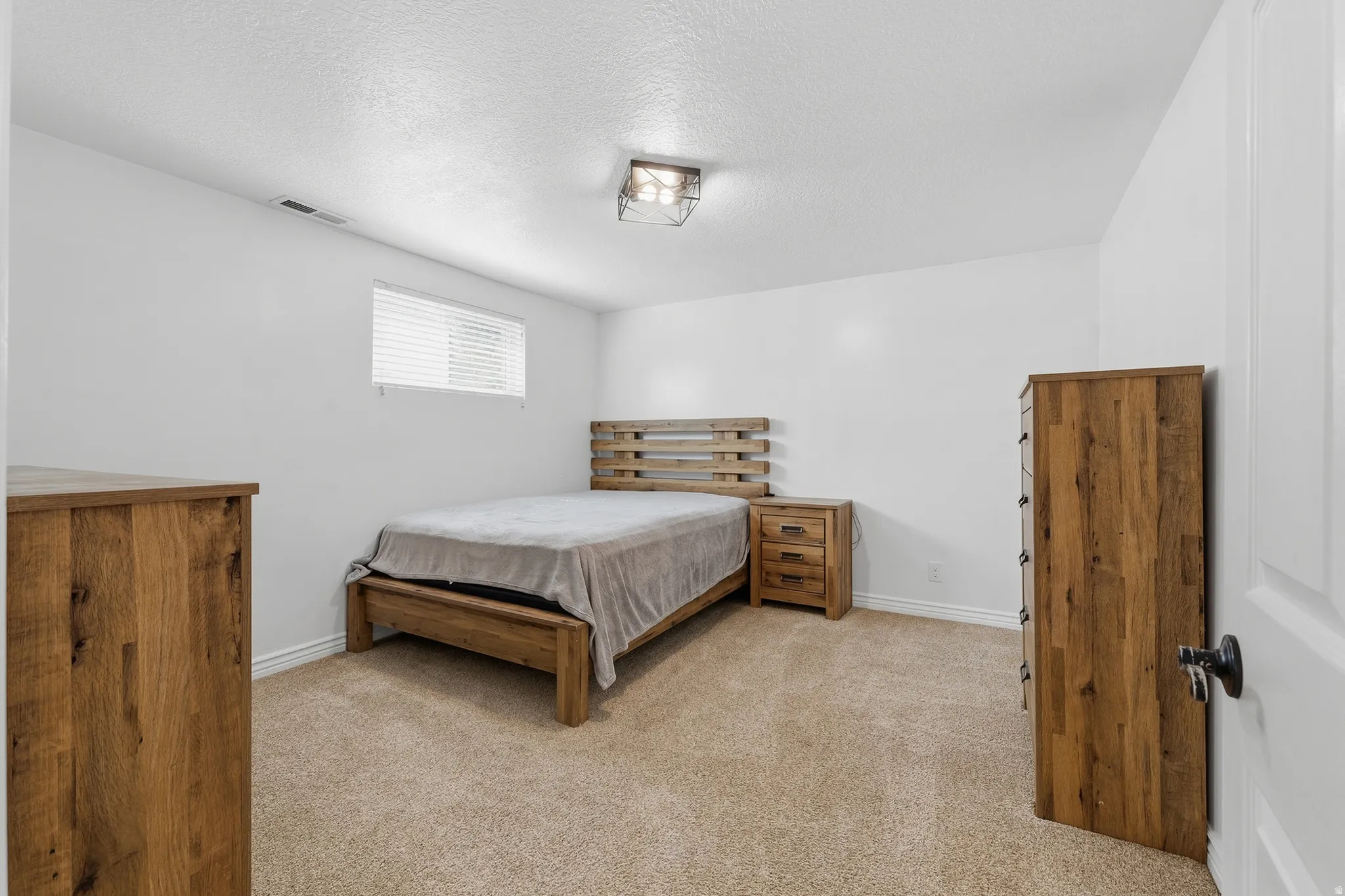 Carpeted room with white painted walls and a flush-mount ceiling light fixture