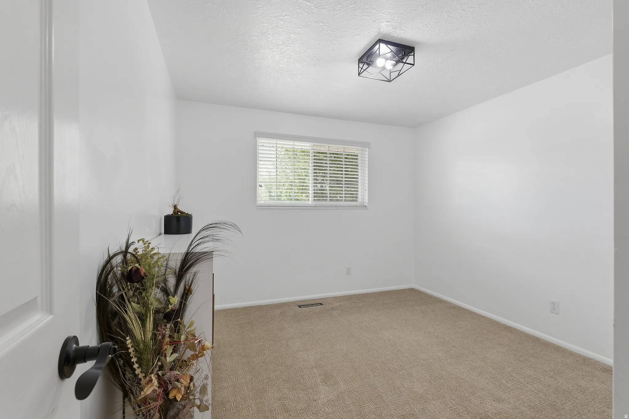 Carpeted flooring, white walls, window with blinds, and a contemporary flush-mount ceiling light