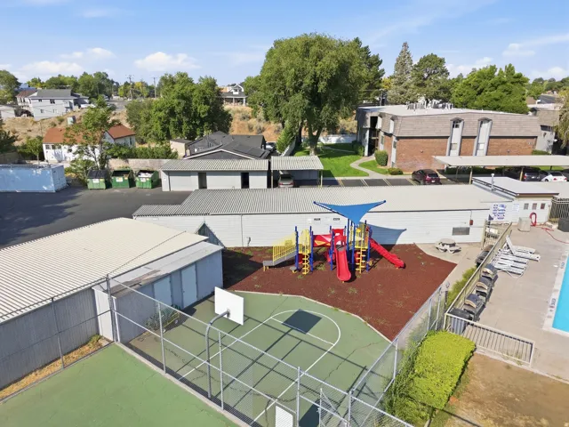 Outdoor playground with canopy, basketball court, and swimming pool