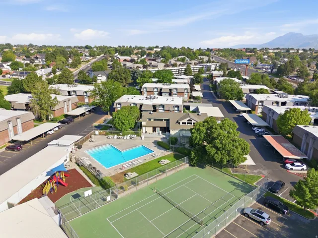 Community featuring a tennis court, outdoor swimming pool, and playground