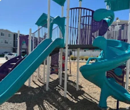 Recreational playground structure featuring multiple slides, stairs, and climbing elements
