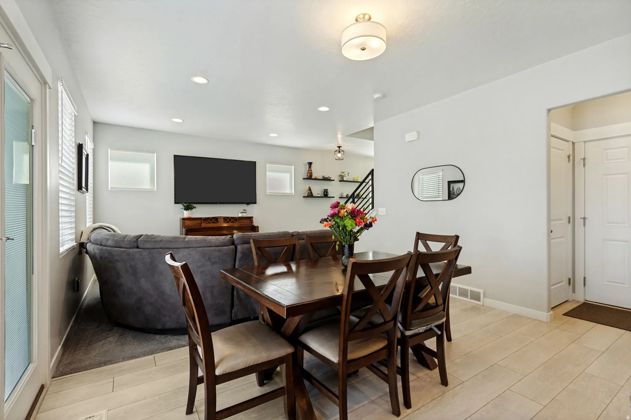 Recessed lighting, wood-finish flooring, white trim, and a glass-paneled door