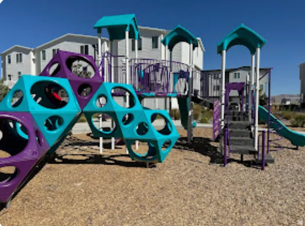 Playground area featuring multiple slides, climbing structures, and protective ground surfacing