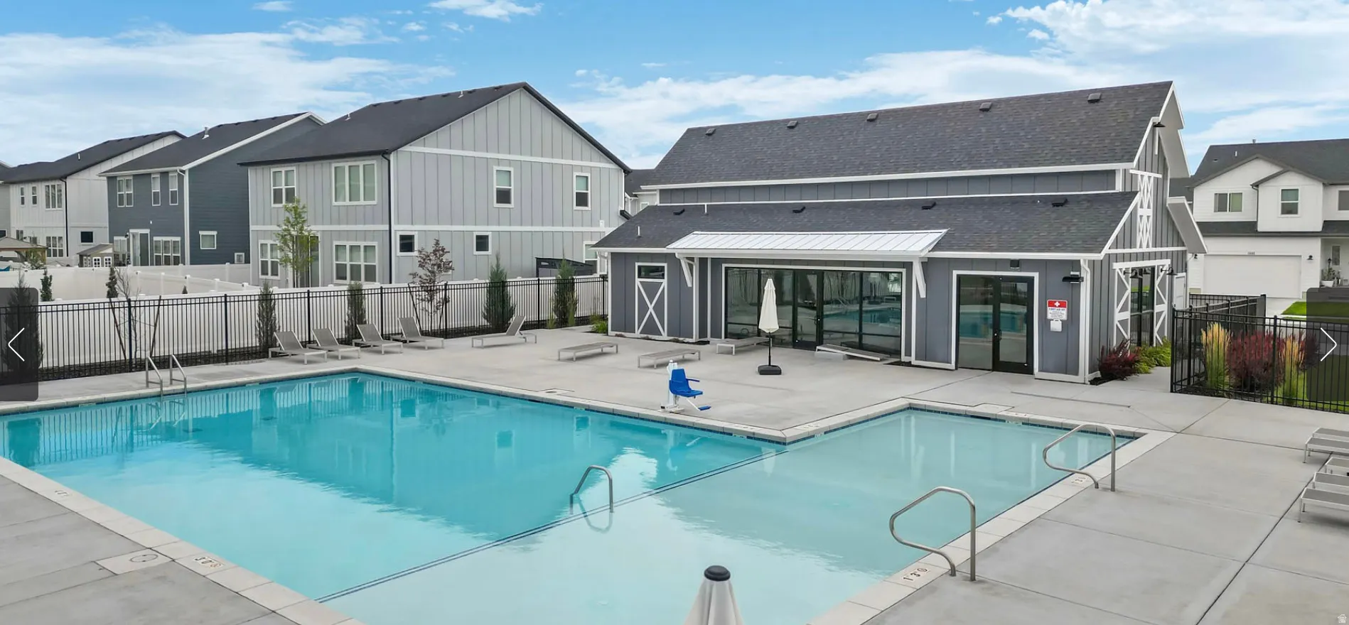 Community pool featuring a large swimming area, an integrated shallow pool, and a surrounding concrete deck