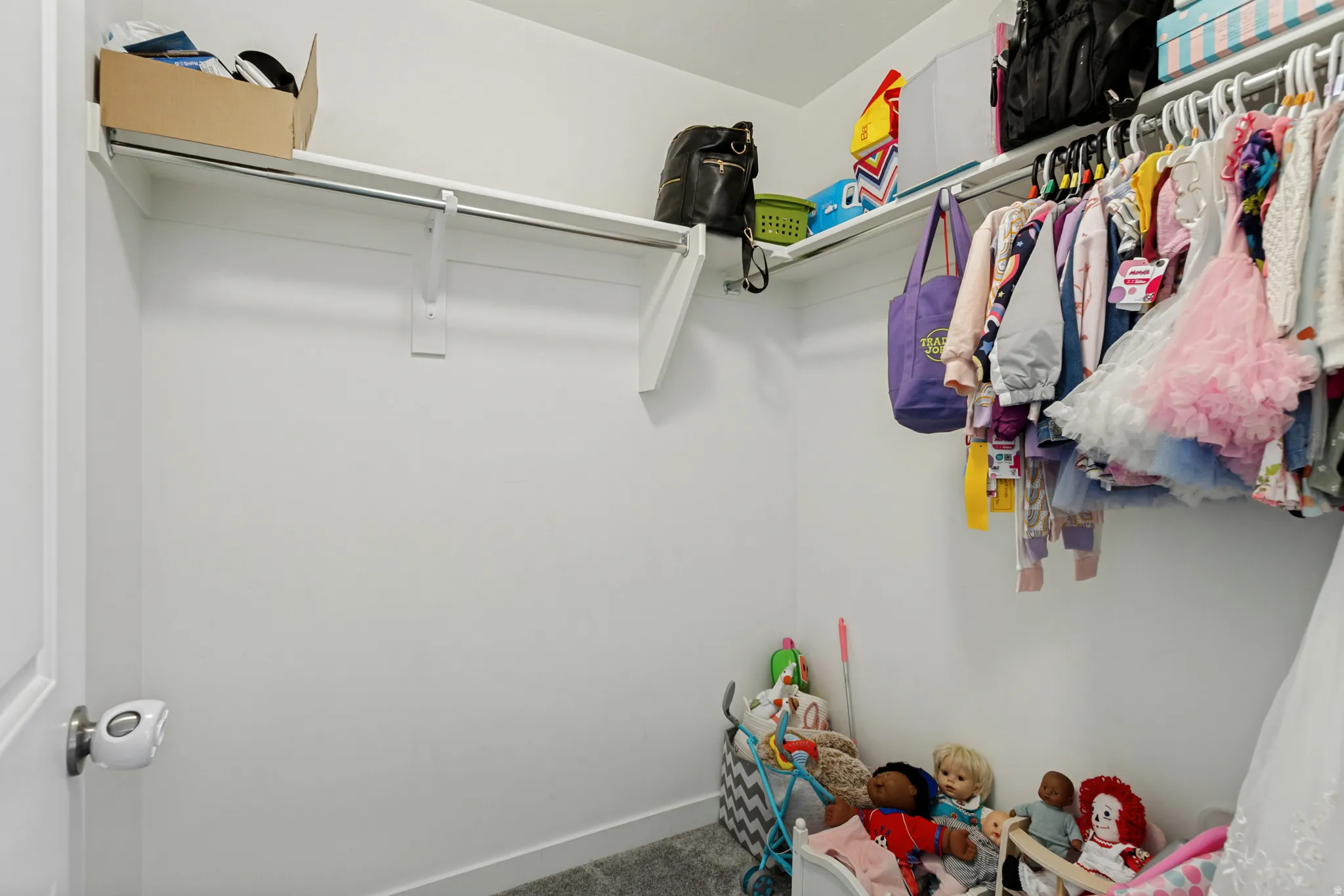 White interior walls with wall-mounted shelving and clothing rods