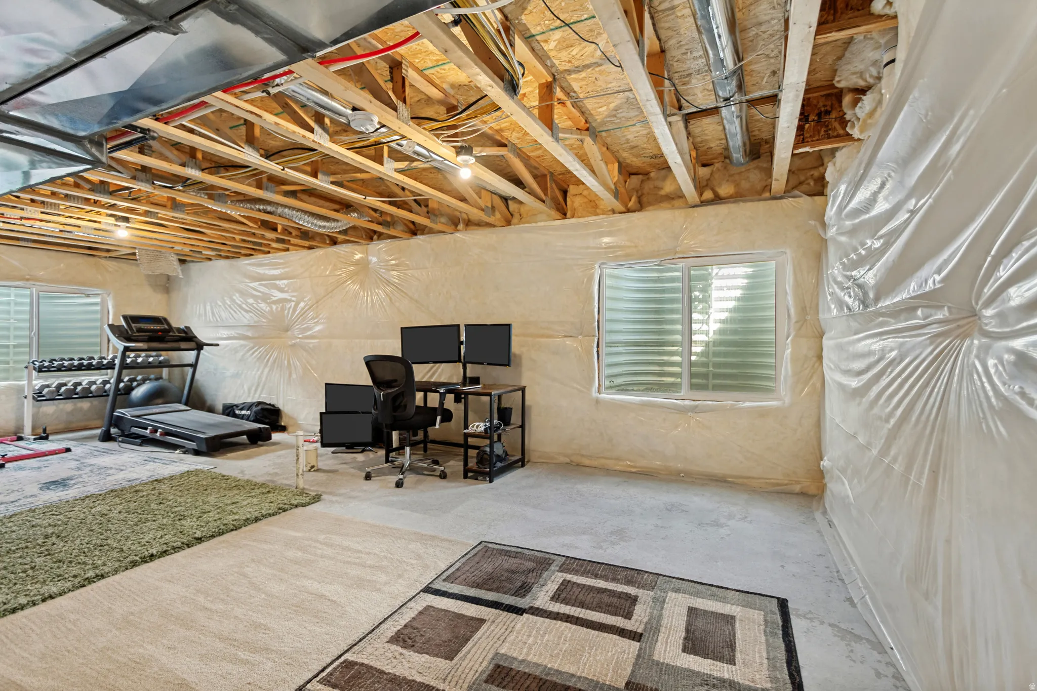 Unfinished basement with exposed ceiling joists and utilities