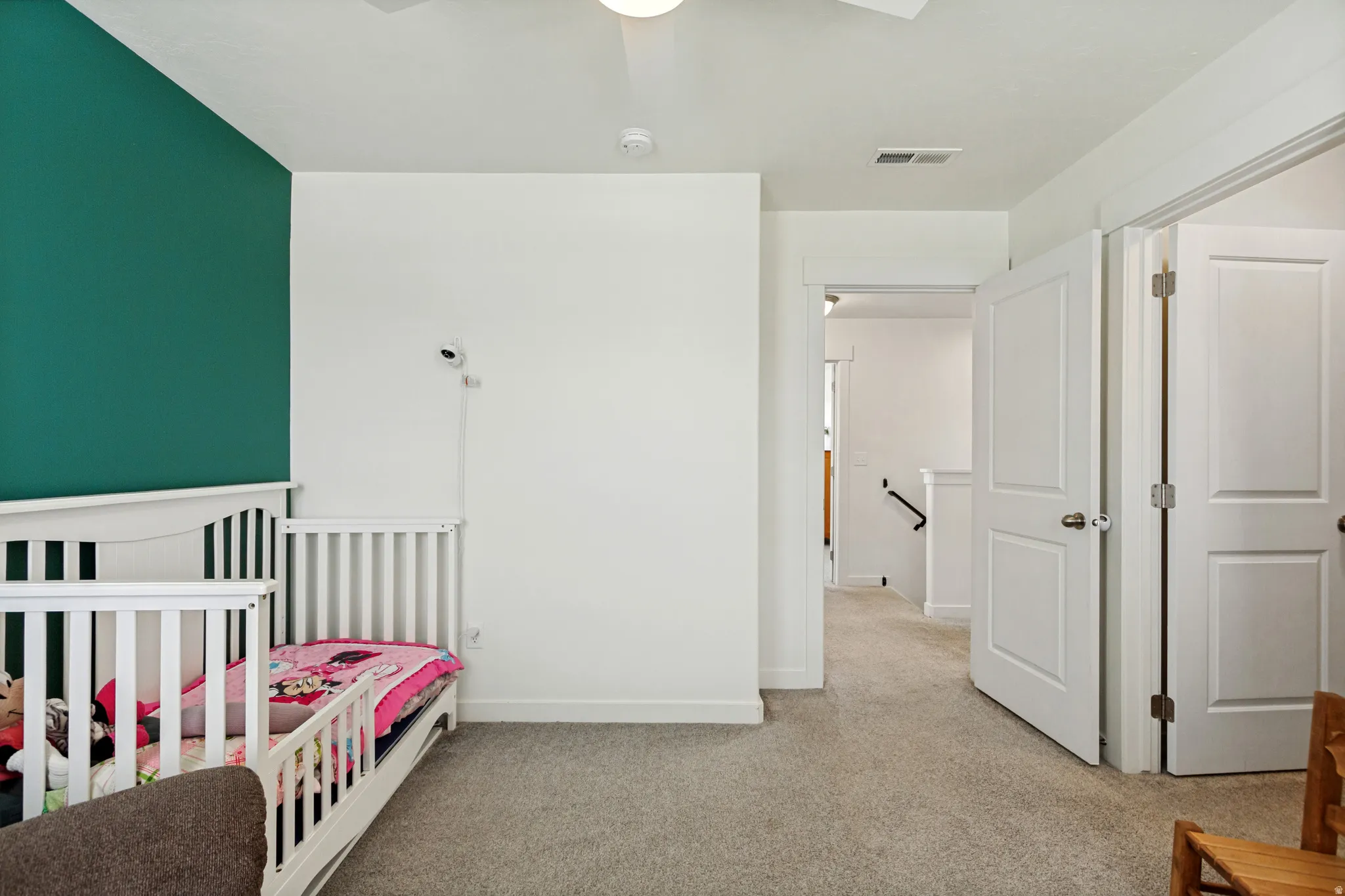 Plush carpeting throughout, white interior doors, and a modern ceiling fan