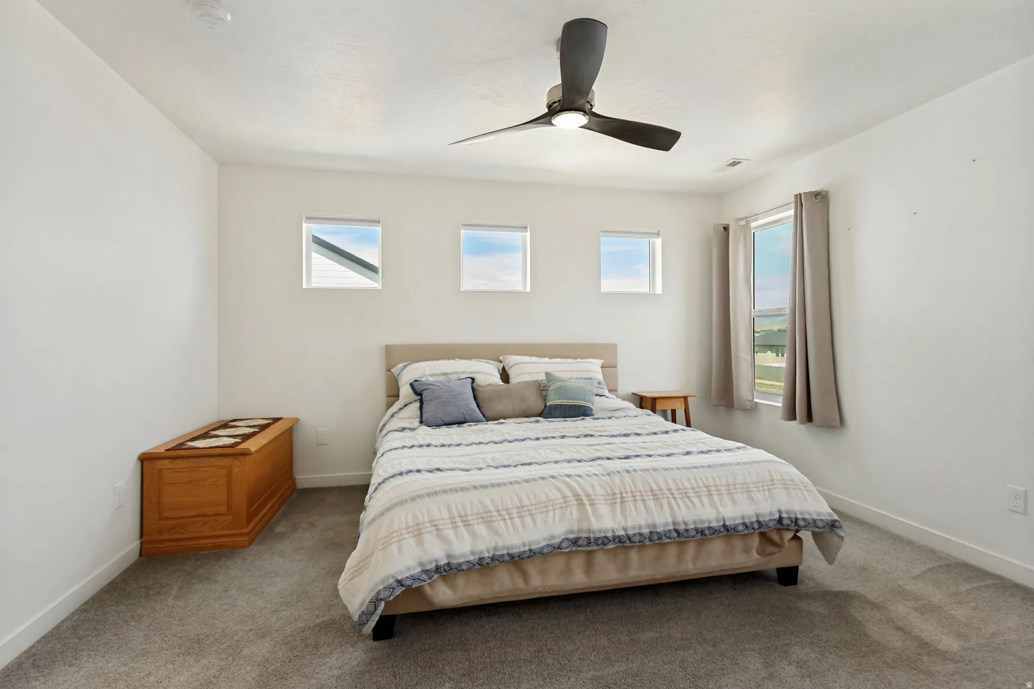 Recessed lighting, ceiling fan, three square accent windows, and a large window with privacy coverings