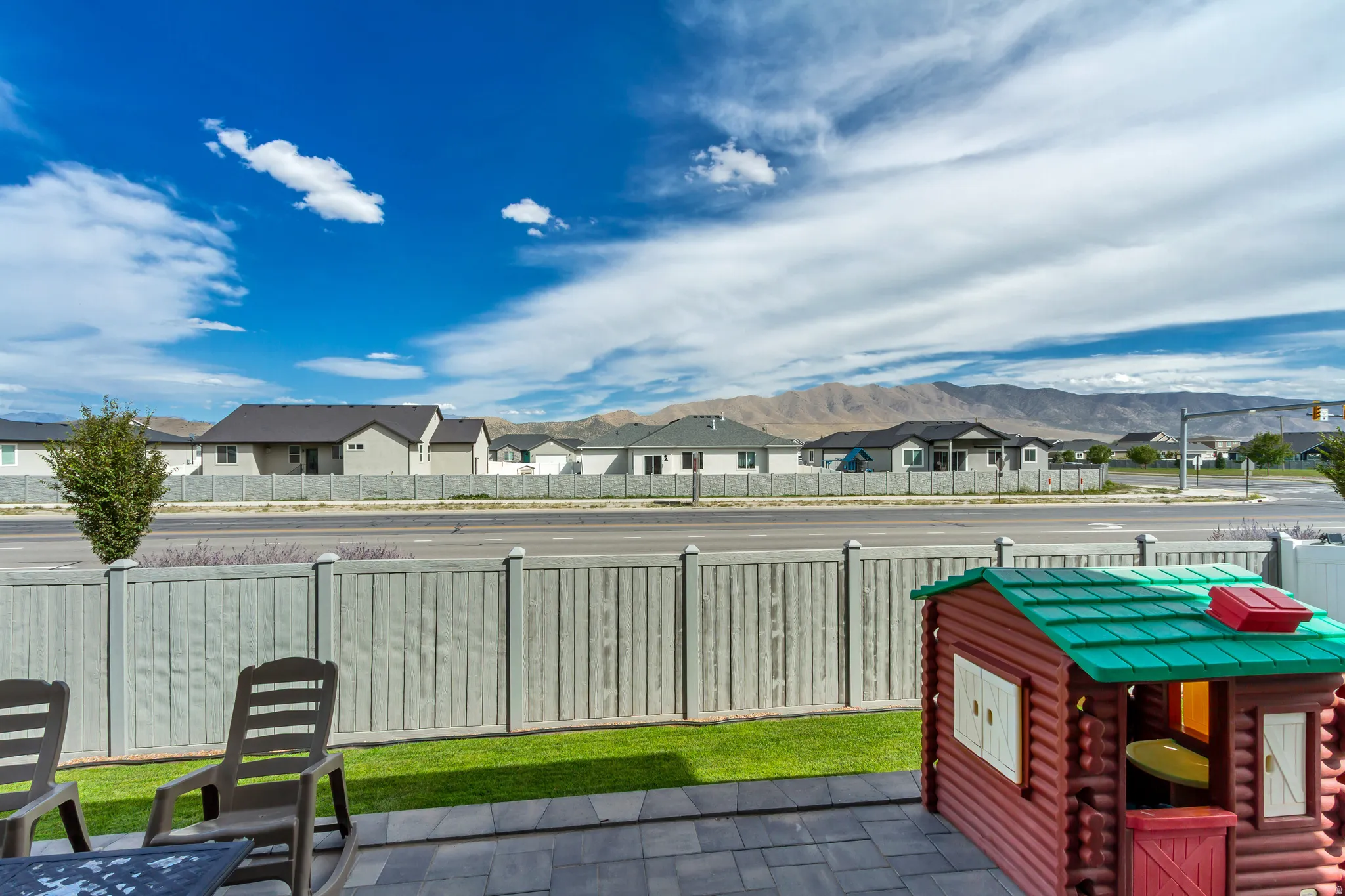Patio area featuring paver flooring, a manicured lawn, and a light-colored privacy fence
