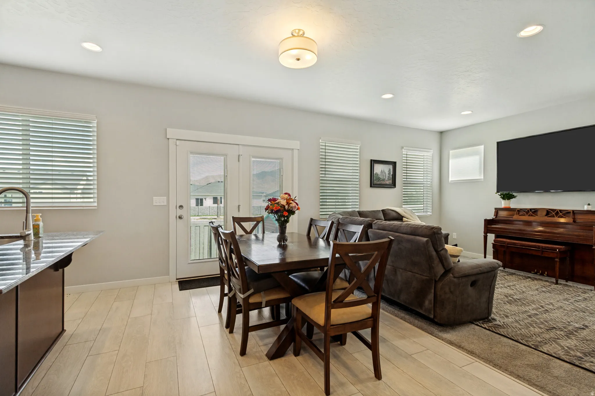 Open-concept living space featuring wood-finish flooring, recessed lighting, and a neutral color palette